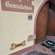 Am Eingang zum Innenhof des Gasthofs zur Gemütlichkeit wird das Schild "Hundebar" montiert