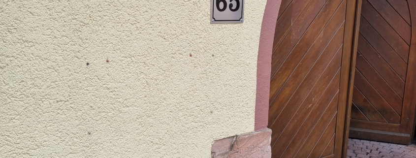 Am Eingang zum Innenhof des Gasthofs zur Gemütlichkeit wird das Schild "Hundebar" montiert