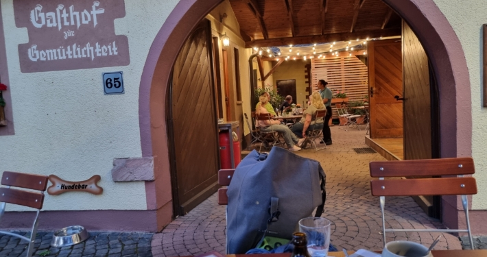Blick in den Innenhof des Gasthofs zur Gemütlichkeit, Service im Gespräch mit Gästen